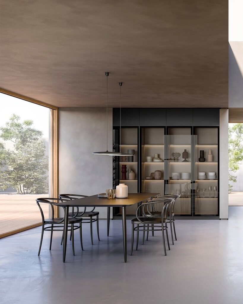 Modern dining area with a sleek black table, matching chairs, pendant lights, and a large glass-front cabinet displaying decorative items, set beside a large window with natural light.