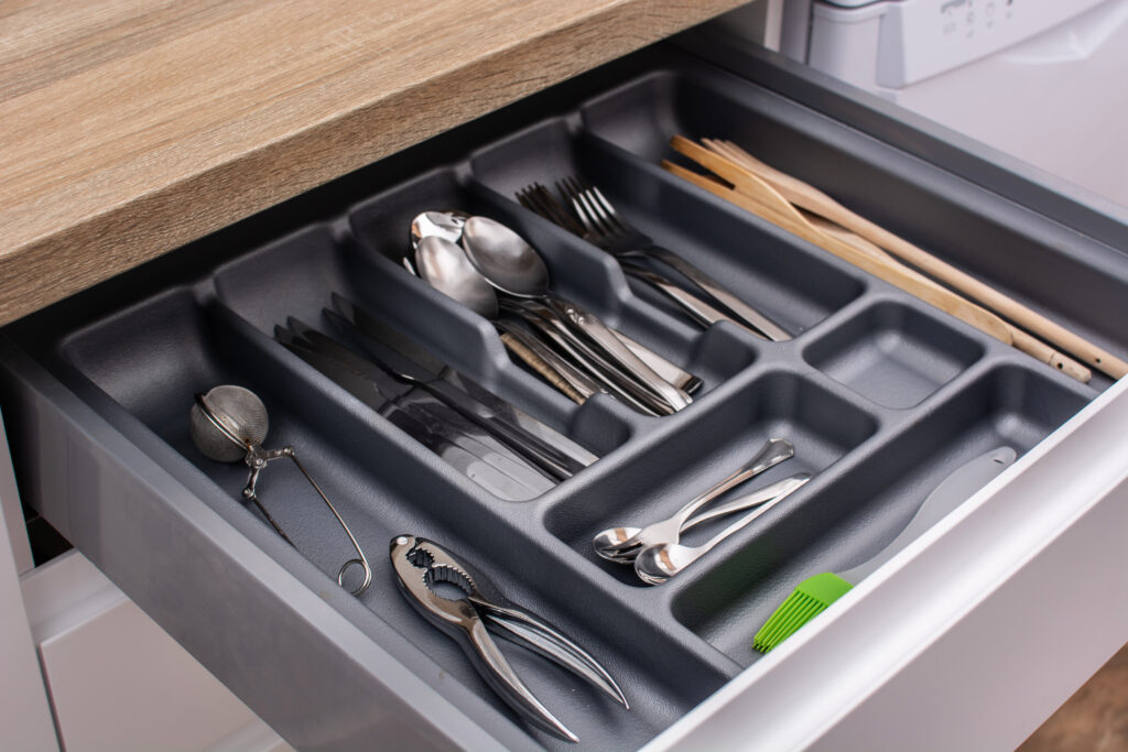 Kitchen drawer organized with cutlery and utensils.