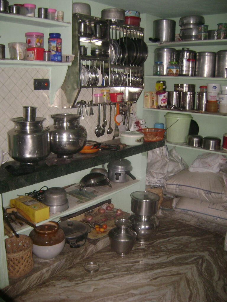 Traditional Indian kitchen interior with steel utensils, storage shelves and cooking essentials